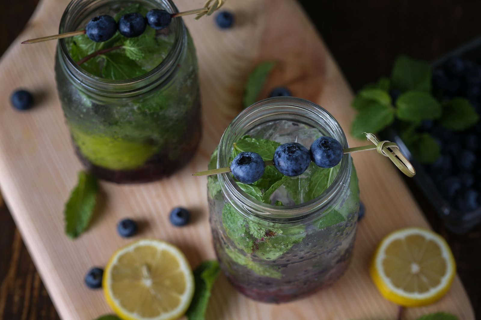Top-down view of blueberry lemonade in jars with mint and lemon slices, perfect for a refreshing summer drink.
