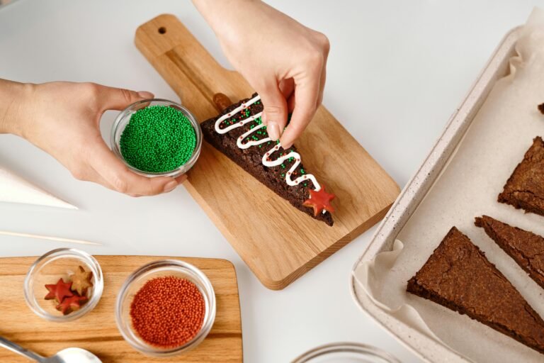 Person decorating Christmas brownies with colorful sprinkles and icing. Perfect for holiday baking themes.